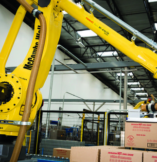 A Robotic Arm Moves Boxes of Sriracha Sauce