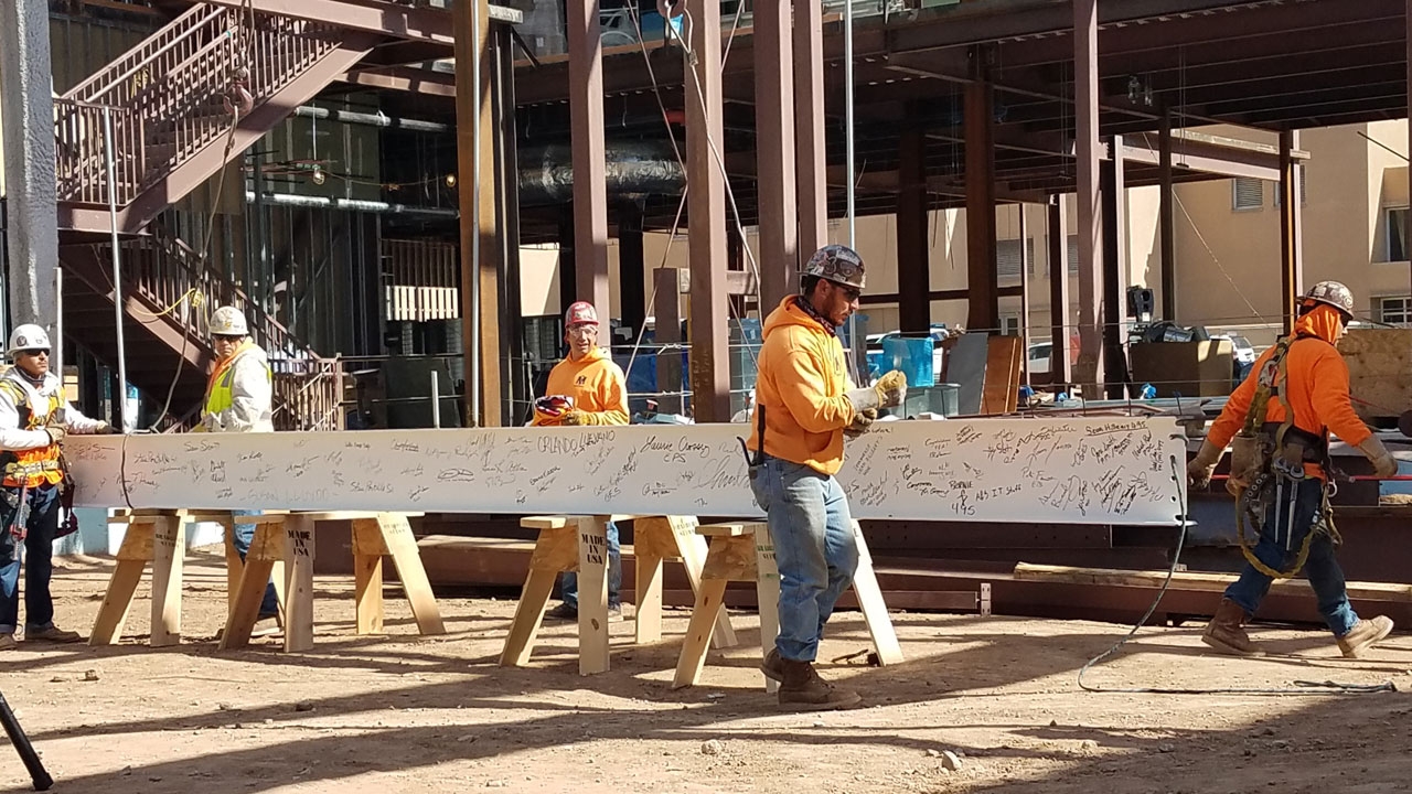 Workers secure beam before raising