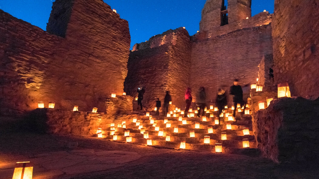 Luminarias illuminate historic building.