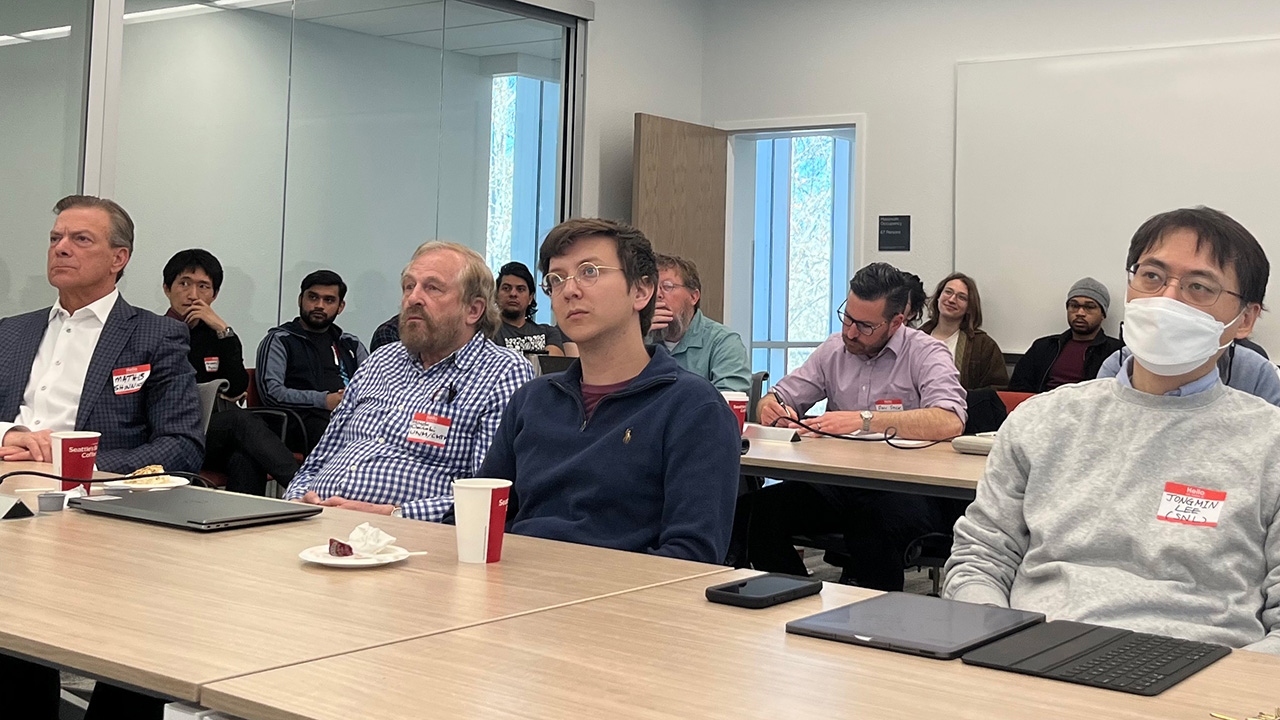 A packed room listens