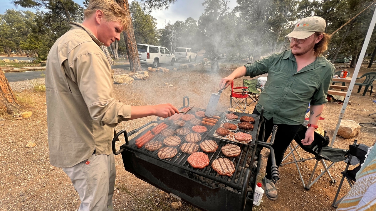 Grilling hamburgers and hotdogs at the campsite