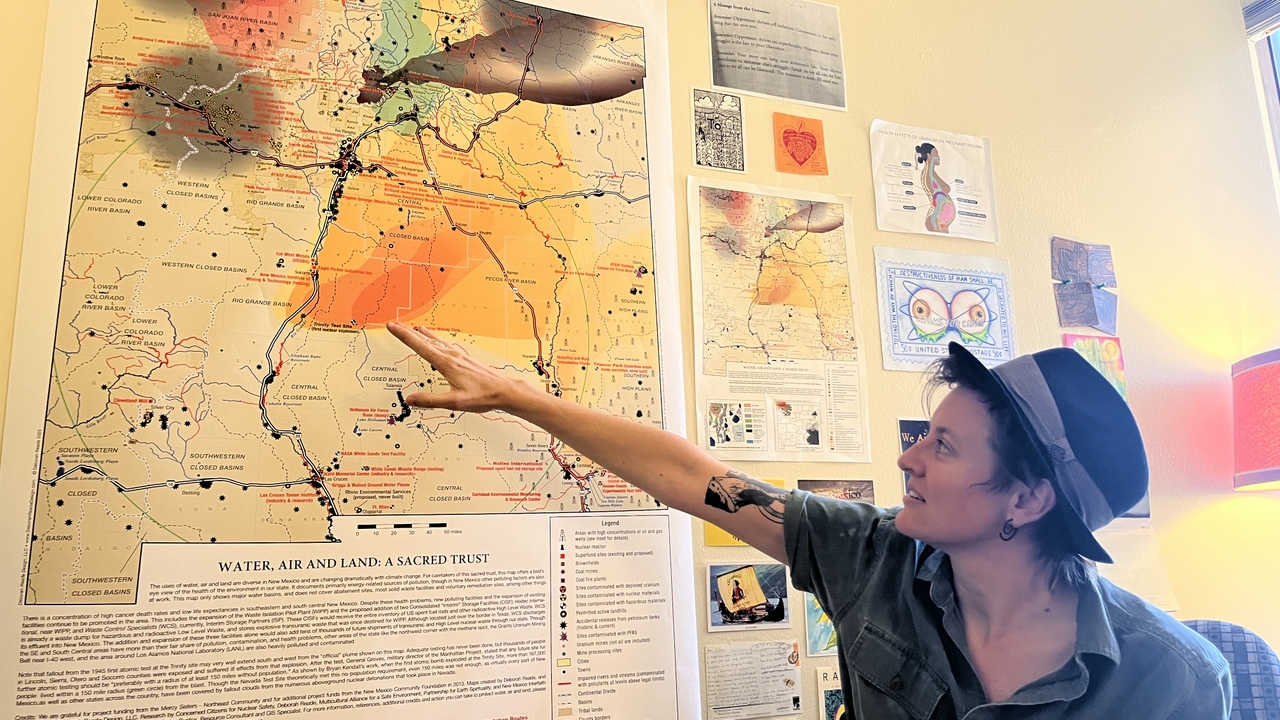 Eileen O'Shaughnessy points to the Trinity Site plume on a map of nuclear impact in her office.