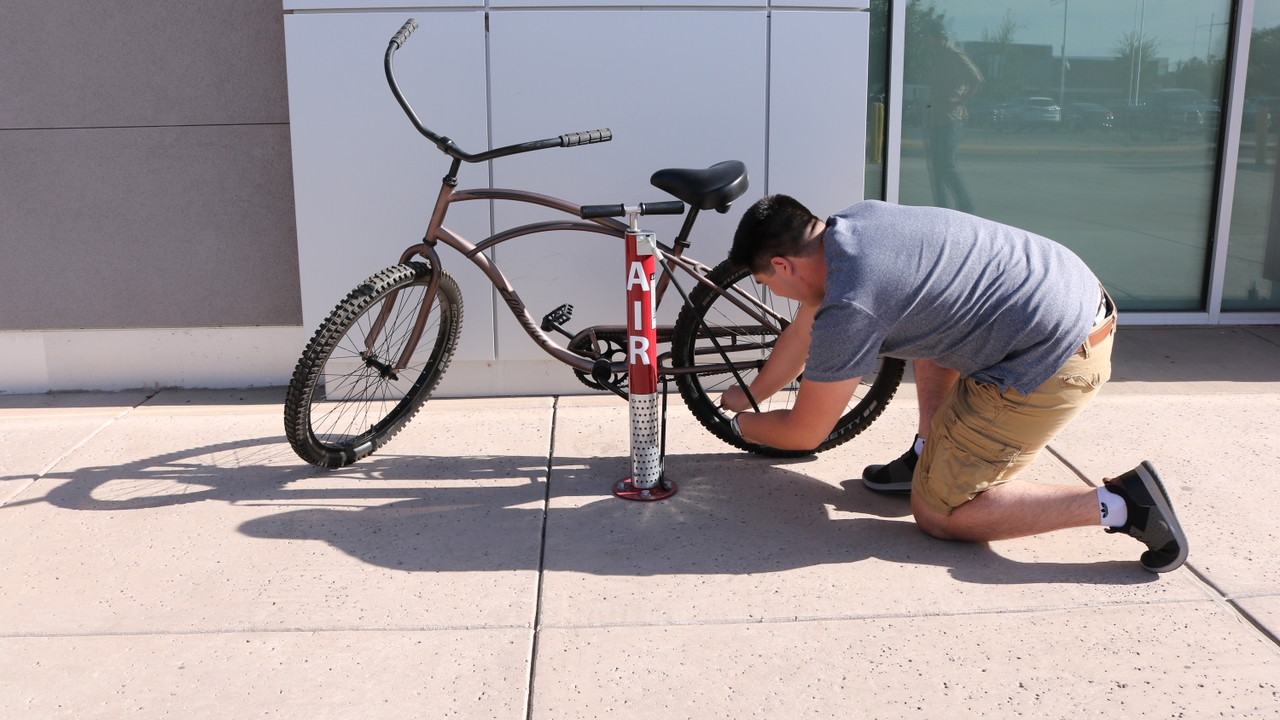 Nicolas Estrada attaching bike pump to the tire