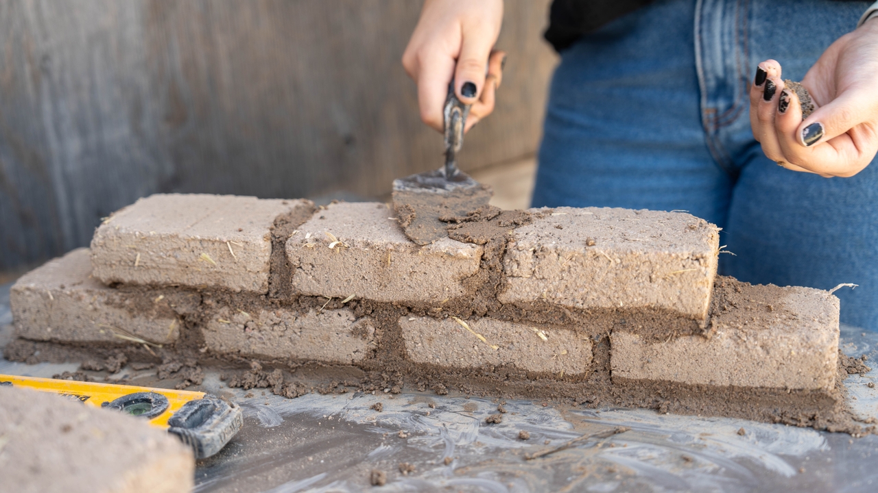 Student building Adobe wall
