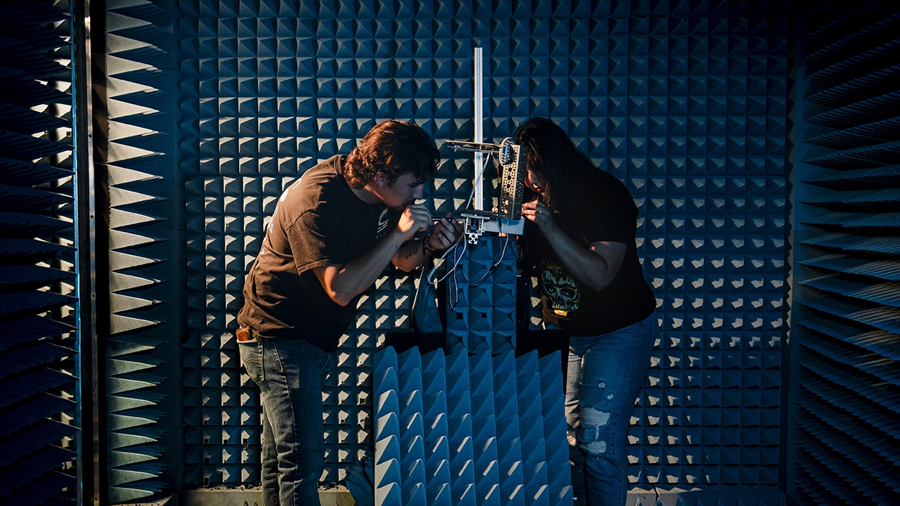 Students in the lab woking on COSMIAC components.