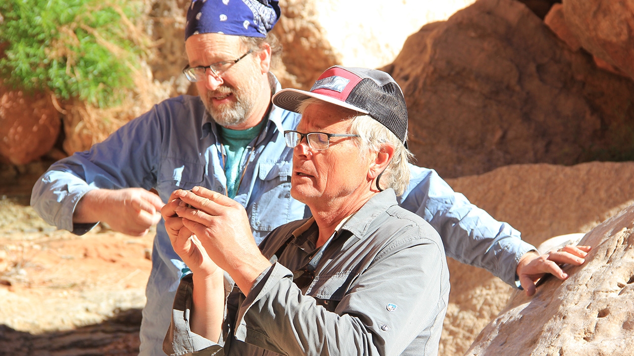 Karl Karlstrom (r.) examining a trilobite fossil 