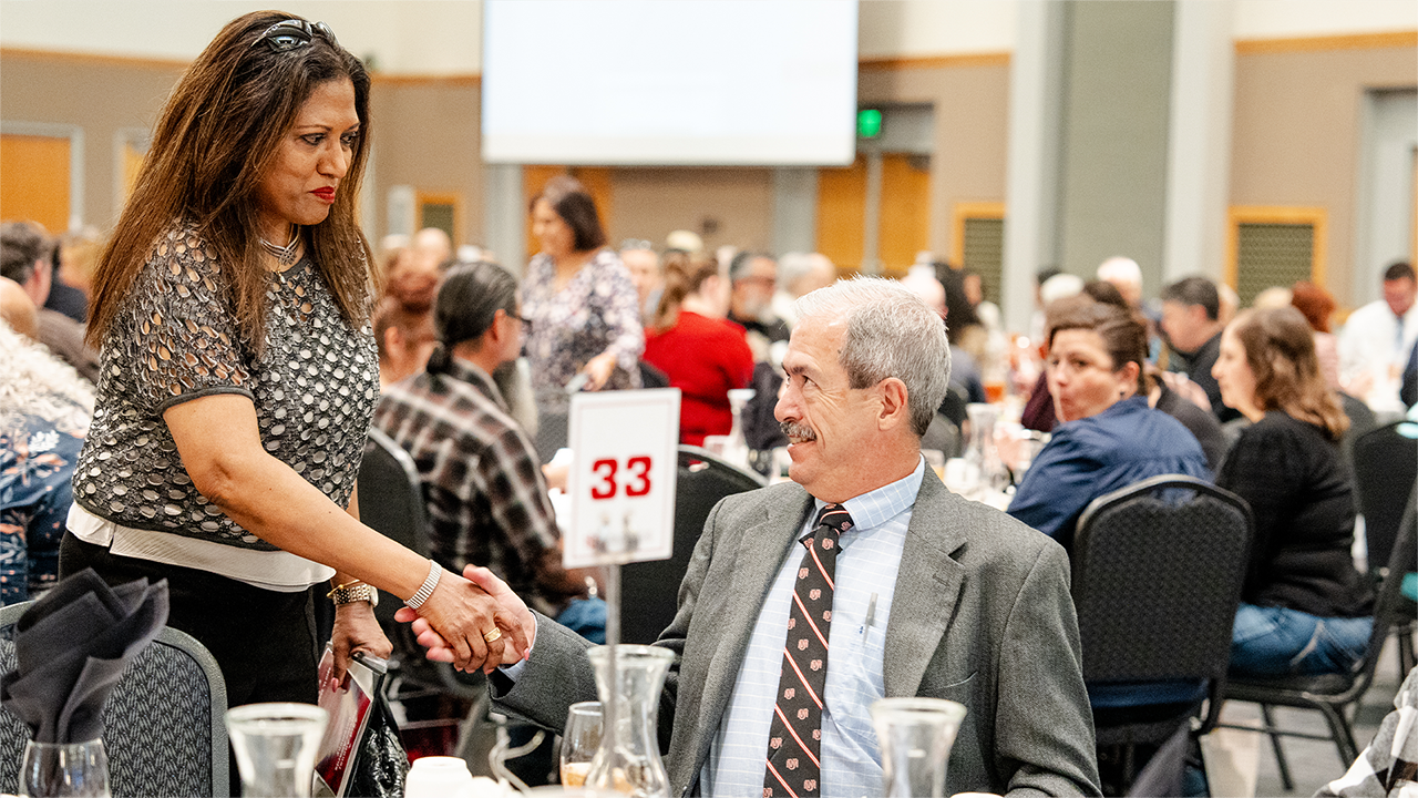 Attendees shaking hands at Service Awards.