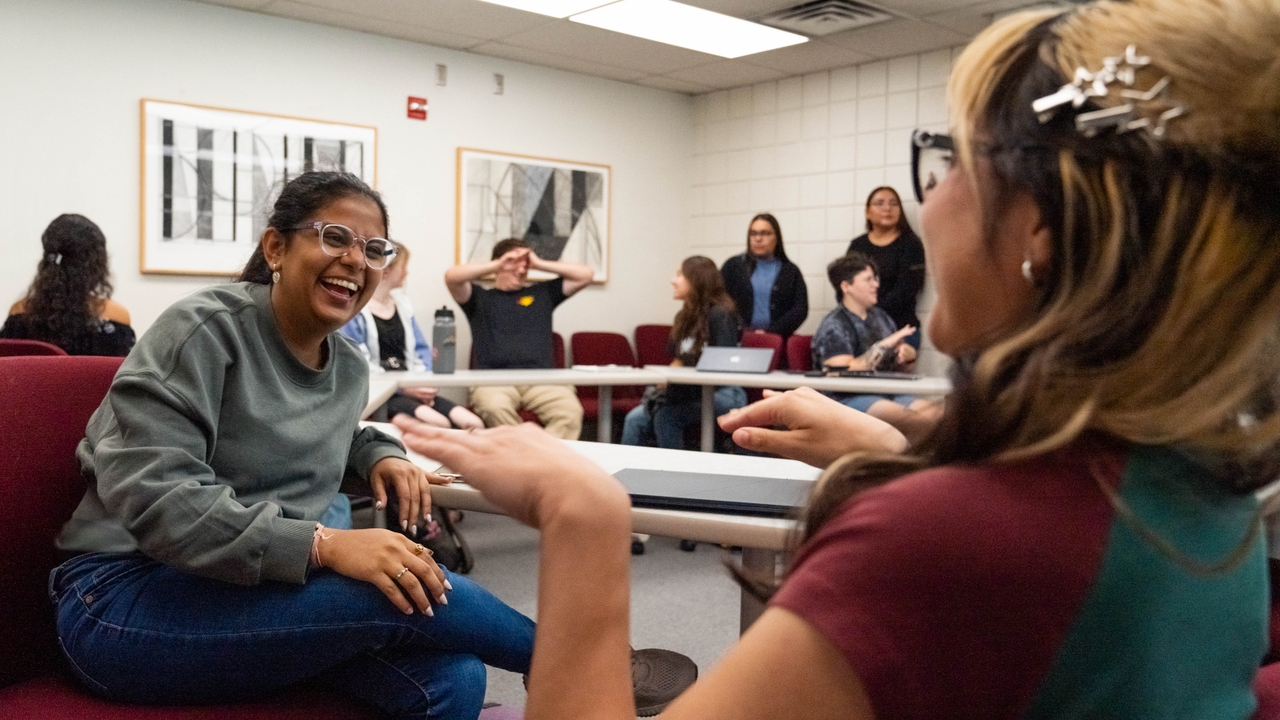 ASL students laugh during a conversation in signed language.