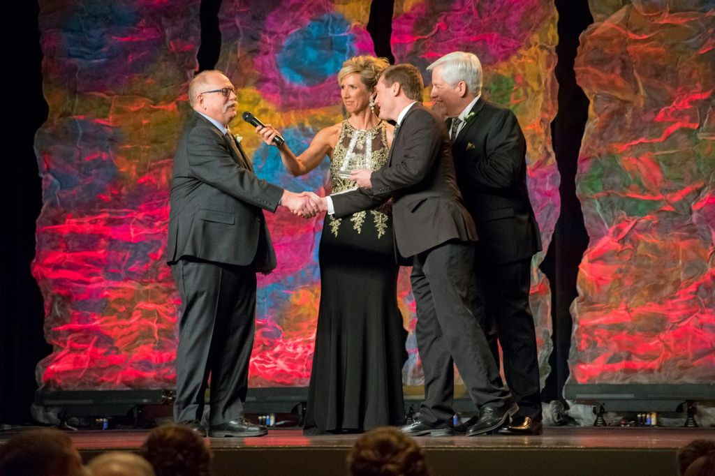 Jason Wilke (second from the right) presents award to Larry Laraby (left) of Preble High School at the Golden Apple Awards Ceremony. 