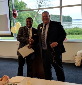 The Rev. Dr. Alexander Gee, Jr. (left) of the Nehemiah Center for Urban Leadership Development receives Associated Bank’s donation presented by Jay Sodey (right).