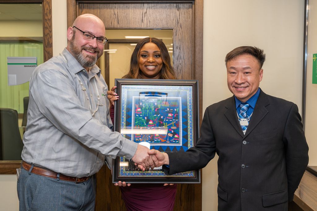 Bill Kopka and Shaneeka White, Associated Bank, accept a paj-ntaub from Lo Neng Kiatoukaysy, Hmong American Friendship Association.
