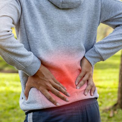 Sport man suffering from backache at park outdoors, Lower back pain concept
