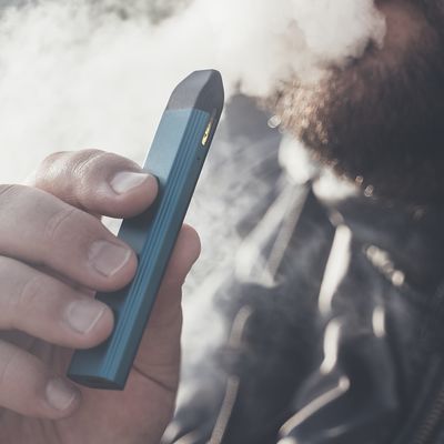 Man smokes new Vape Pod System, inhales and exhales vapor of electronic cigarette, vaping concept