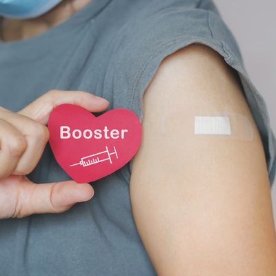 senior woman show red heart shape with syringe icon,  after vaccinated or inoculation  booster dose  due to spread of corona virus, population, social or herd immunity concept