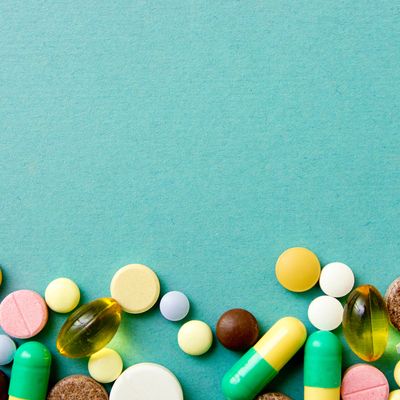 Many colorful pills on red background with copy space. Pattern , Identification of pills