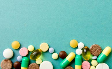 Many colorful pills on red background with copy space. Pattern , Identification of pills