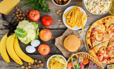 Fastfood and healthy food on old wooden background. Concept choosing correct nutrition or of junk eating. Top view.