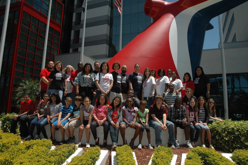 Parents and kids took time during the day for a group picture infront  of Carnival Cruise Lines' funnel located outside its Miami headquarters.