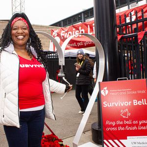 Woman wearing a survivor shirt rings the survivor bell