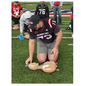 Participant at Senior Bowl practicing AED usage