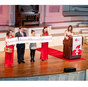 Volunteers display signs symbolizing the four pillars of the AHA