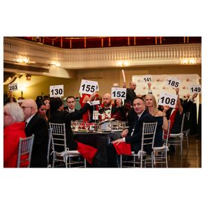 Guests raise pledge cards at the the 2025 Central Massachusetts Heart and Stroke Ball 
