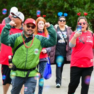 A walker celebrates as they approach the finish line